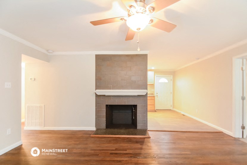 a living room with a fireplace and a ceiling fan