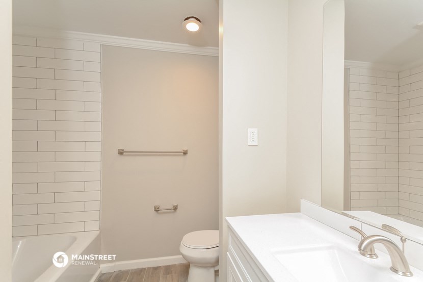 a bathroom with a toilet and a tub and a sink