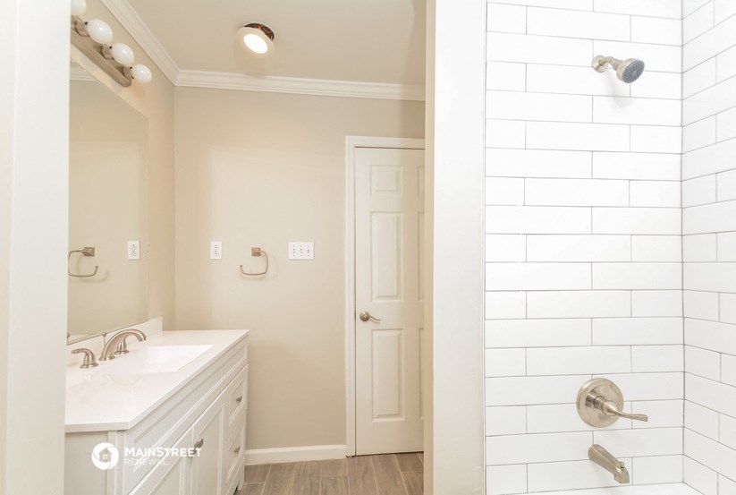 a bathroom with a shower and a sink and a mirror