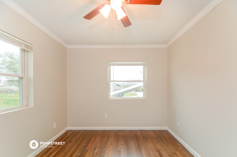 an empty room with a ceiling fan and a window