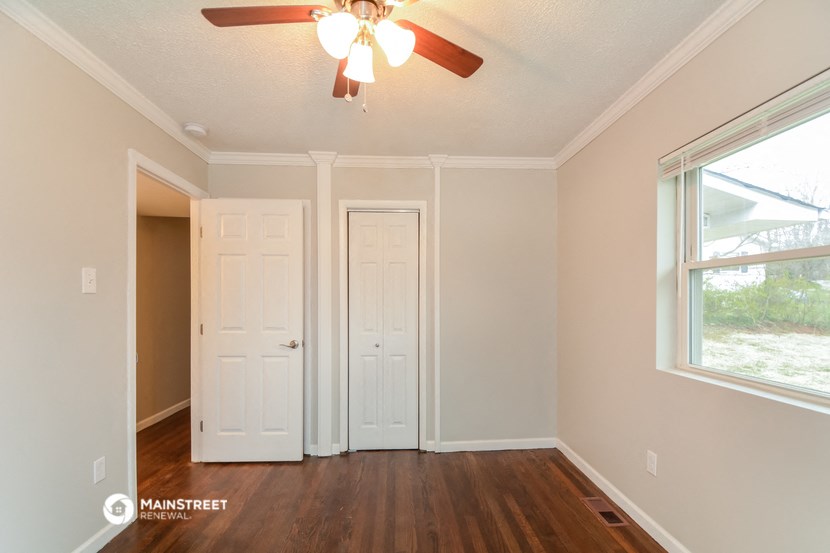 a bedroom with two doors and a ceiling fan