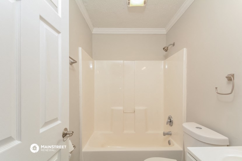 a white bathroom with a shower and a toilet