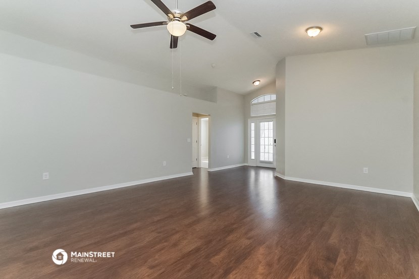 the living room and dining room with hardwood flooring and a ceiling fan
