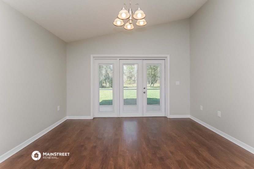 the living room of a house with a wood floor and white doors