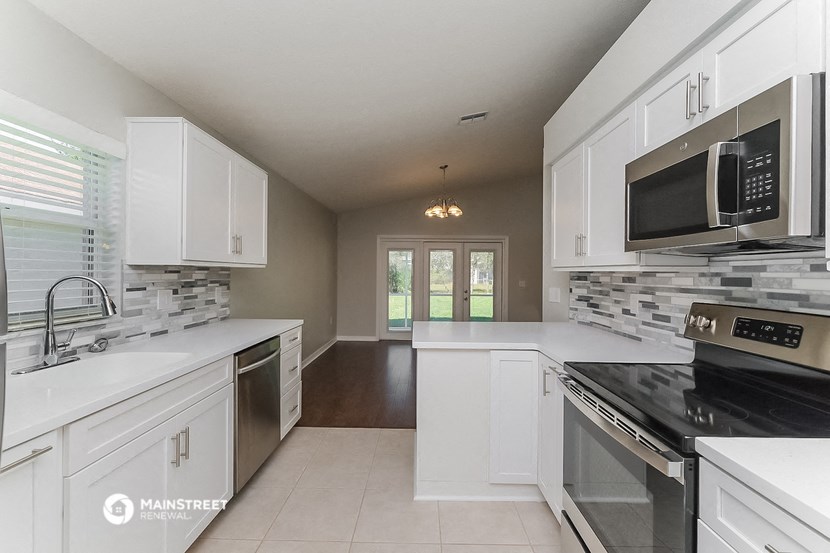 a kitchen with white cabinets and a stove and a microwave
