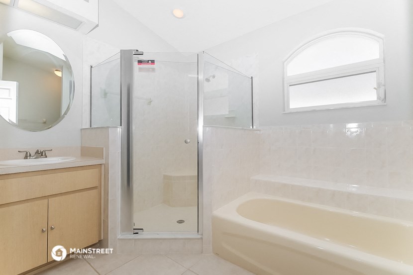 a bathroom with a tub and a shower and a sink