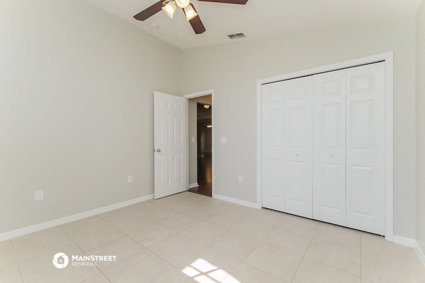 an empty living room with two closets and a ceiling fan