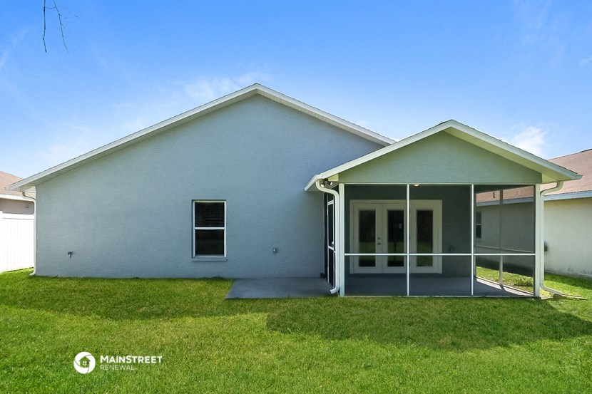 a white house with a lawn and a blue sky