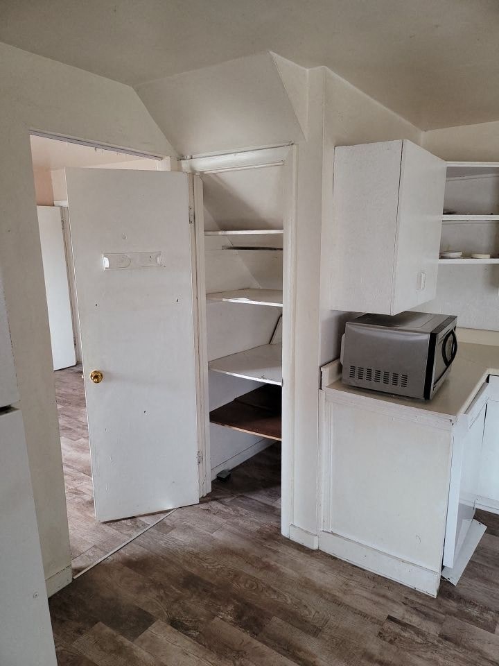 an empty room with a refrigerator and cabinets