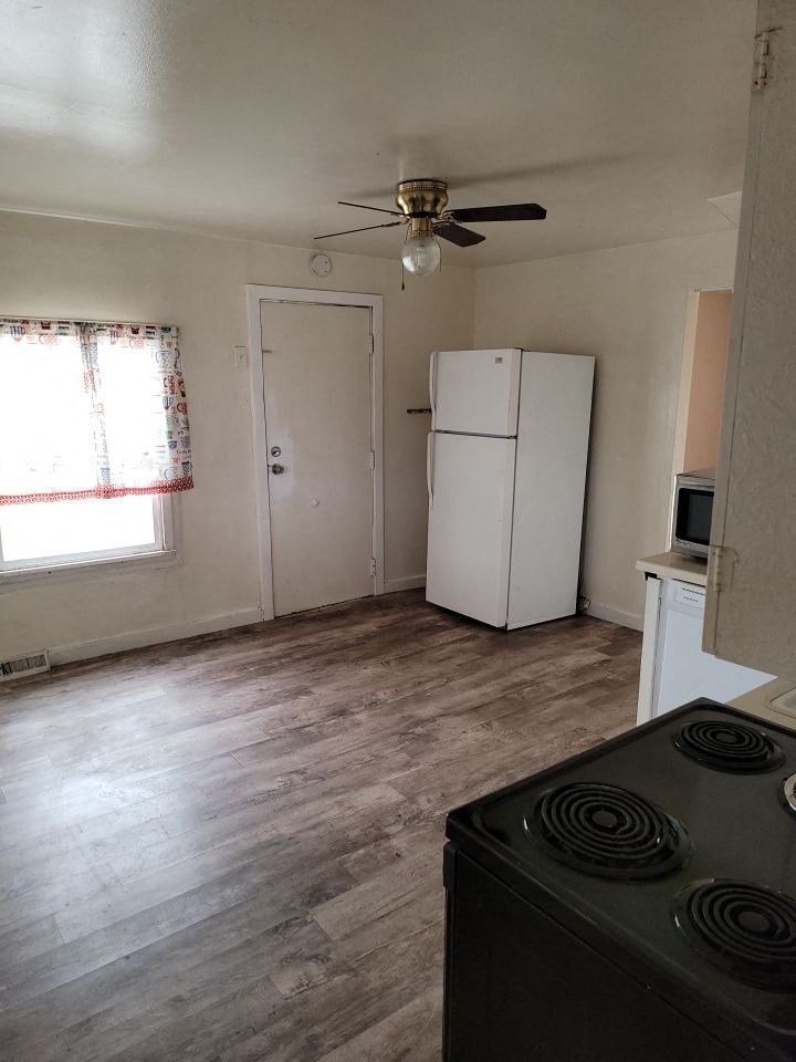 an empty kitchen with a stove and a refrigerator