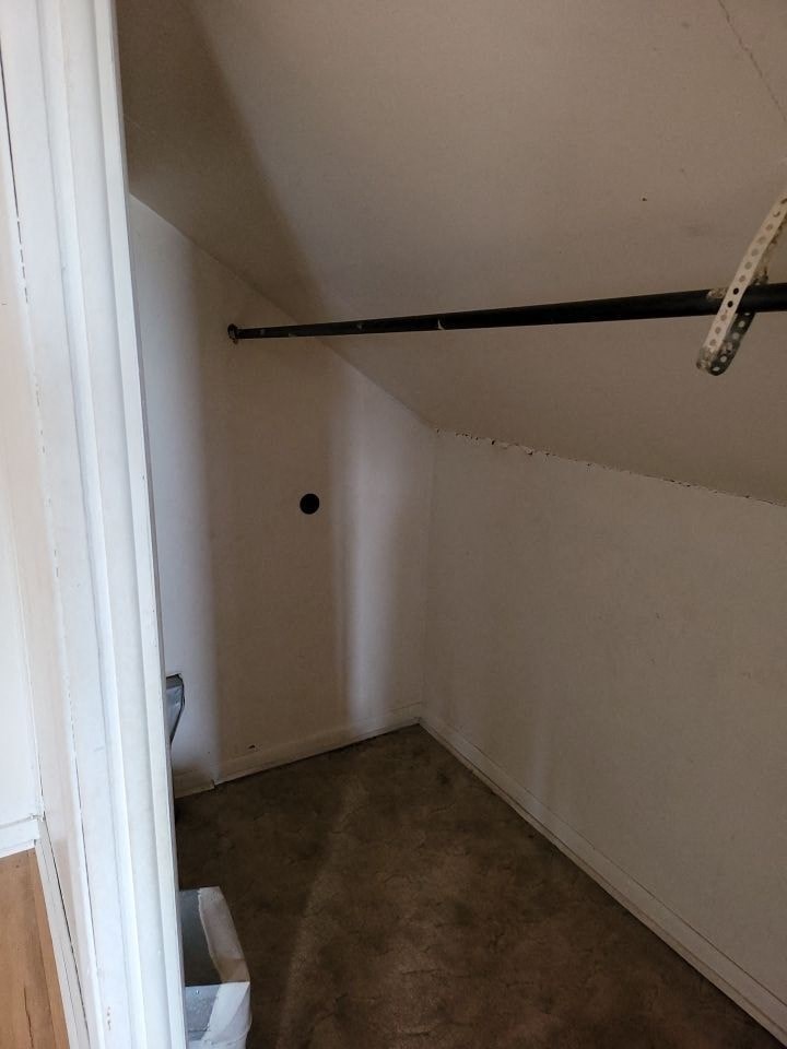 a small room with a toilet and a black rail in it