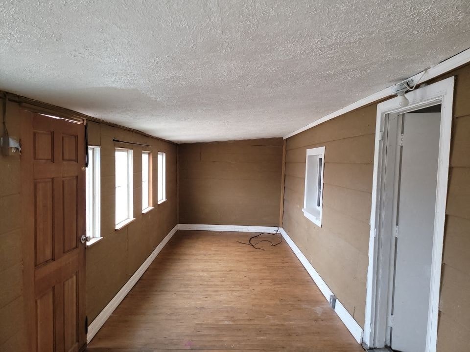 an empty room with a wooden floor and a door