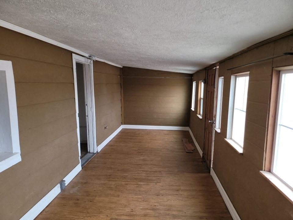a living room with a wooden floor and brown walls