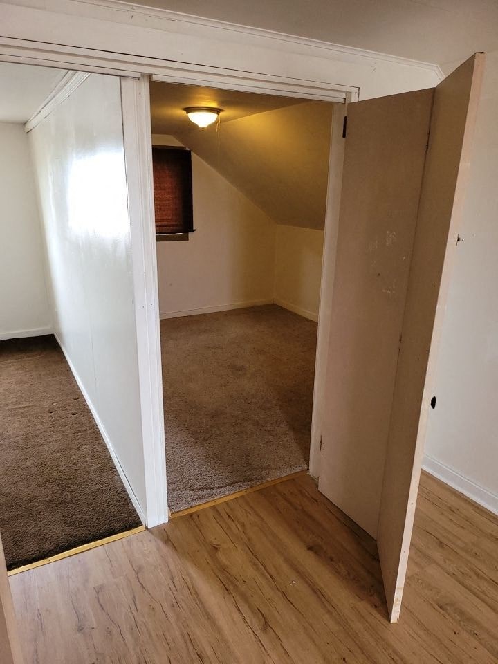 an empty room with a door open to a living room
