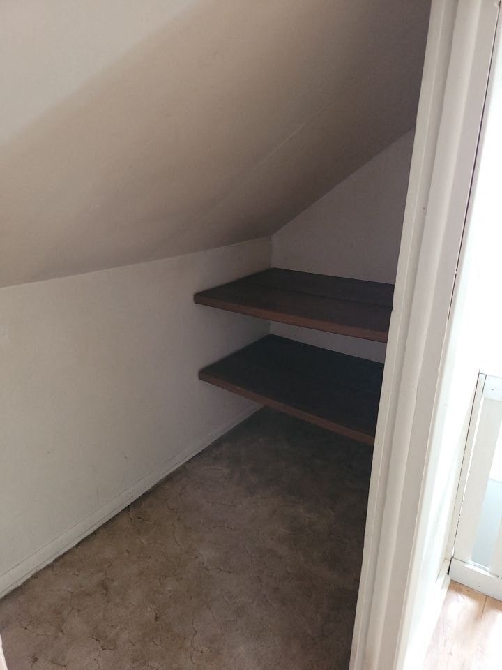 an empty attic with three shelves in it