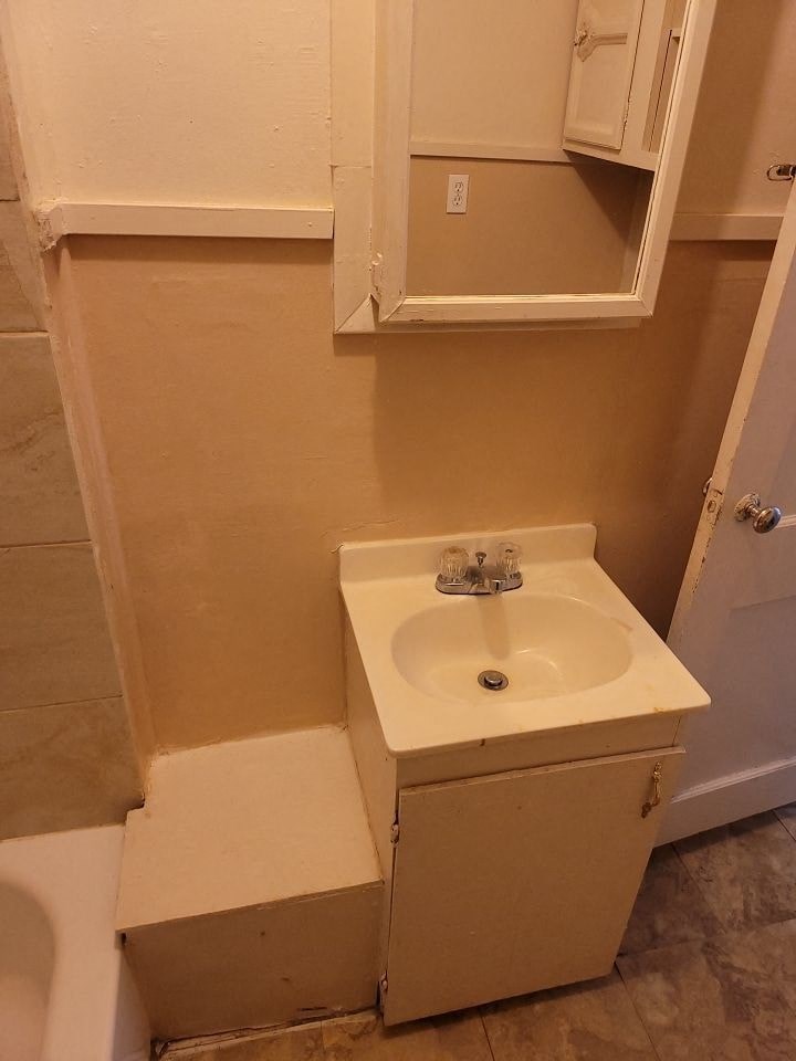a small bathroom with a sink and a tub