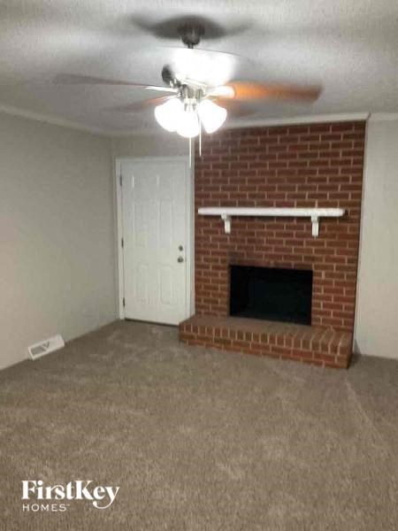 A room with a fireplace and a ceiling fan.