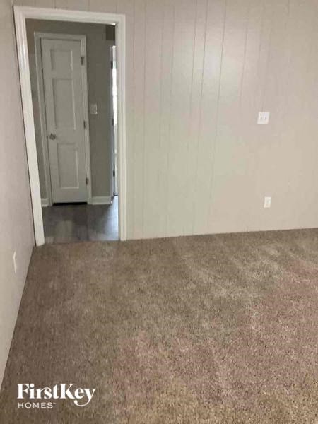 A room with a carpeted floor and a doorway leading to another room.
