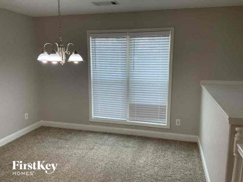 an empty dining room with a window and two lights