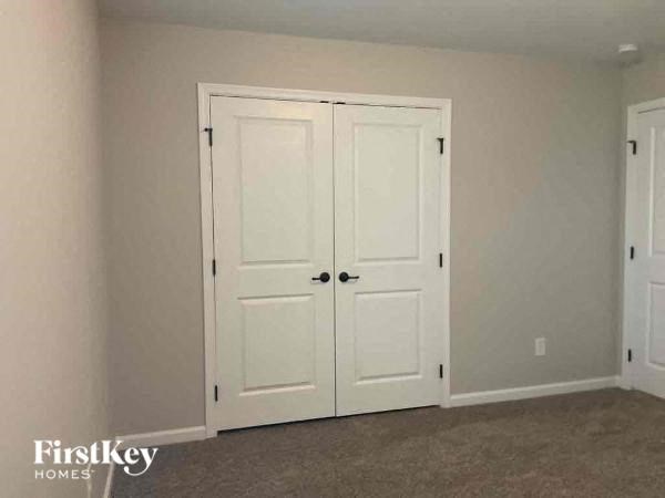 a bedroom with two white doors and a carpeted floor