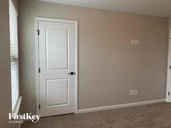 an empty room with a white door and a window