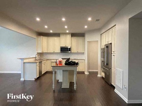 a large kitchen with white cabinets and a table