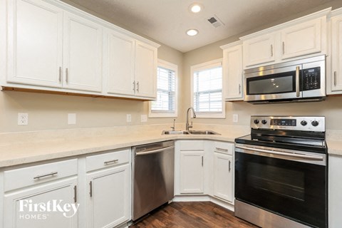 A kitchen with white cabinets and a stainless steel dishwasher.