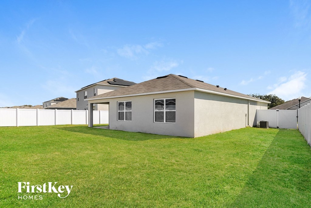 A house with a fence and a grassy yard.