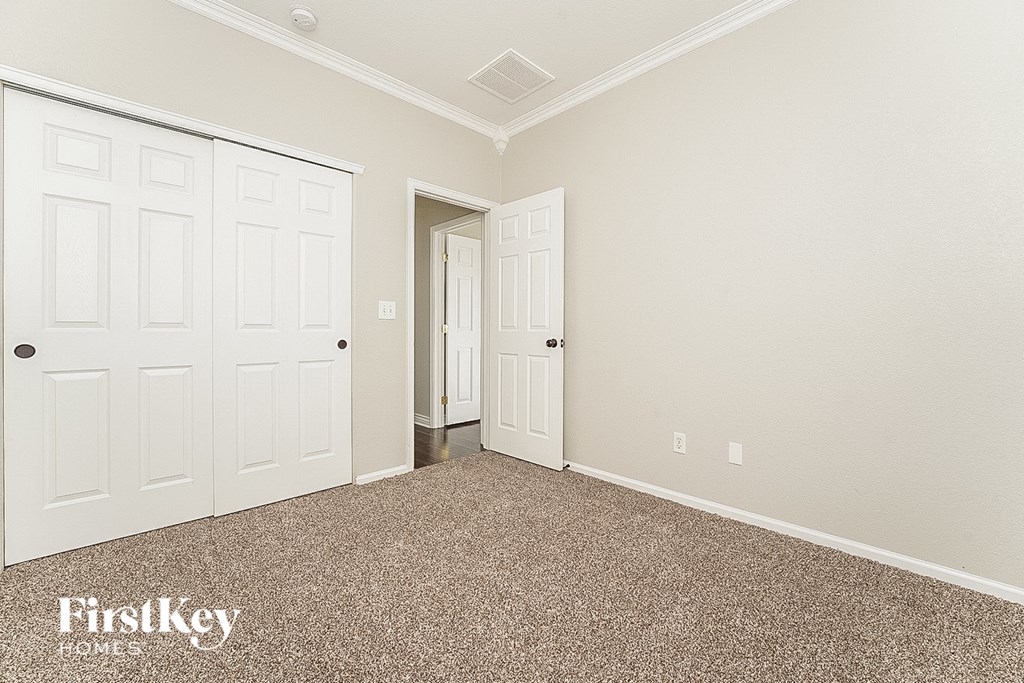 a bedroom with two closets and a carpeted floor