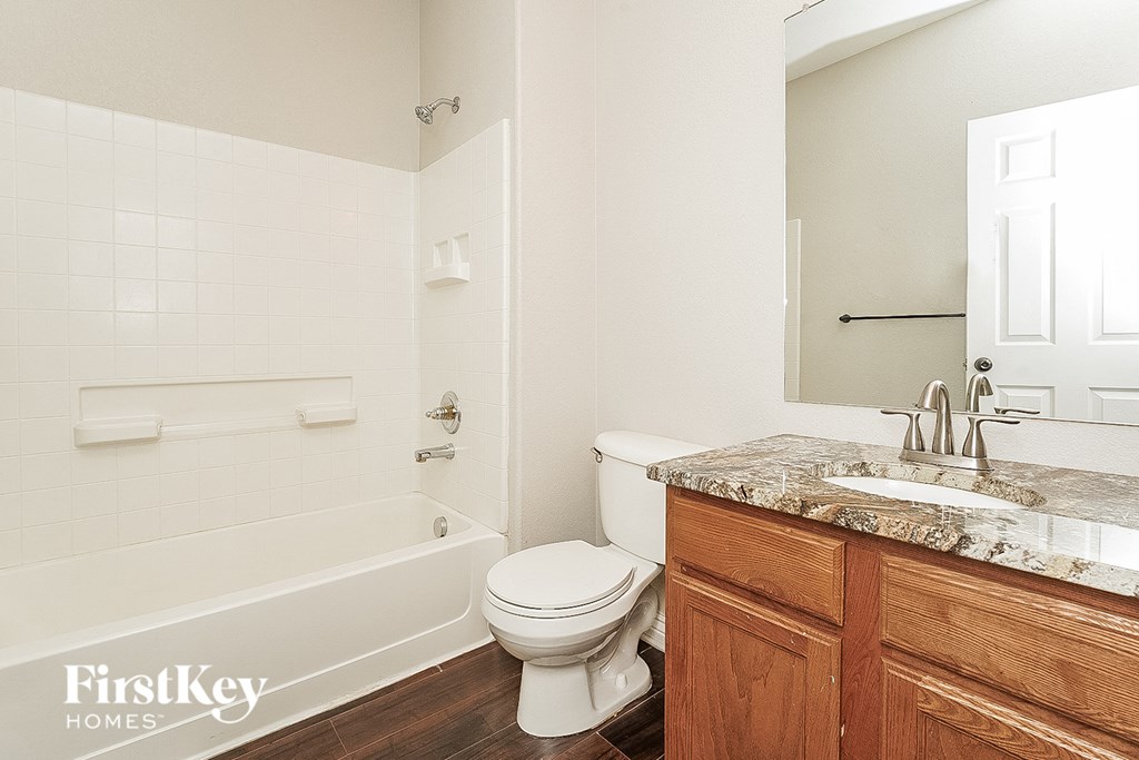 a bathroom with a toilet and a tub and a sink