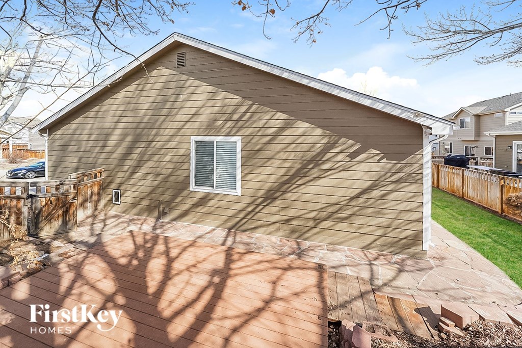 the back of a house with a yard and a wooden fence