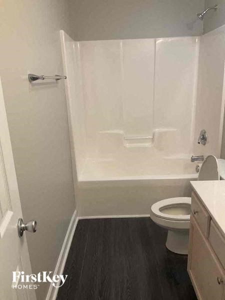 a white bathroom with a toilet and a tub