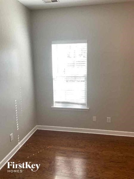 a empty room with a window and wooden floors