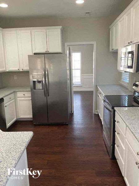 a kitchen with white cabinets and a stainless steel refrigerator