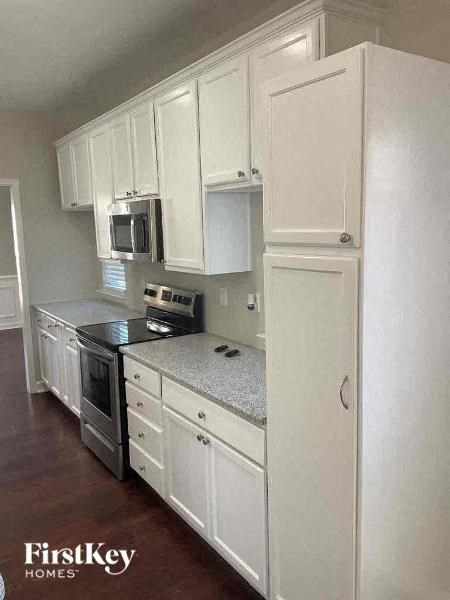a kitchen with white cabinets and a stove and