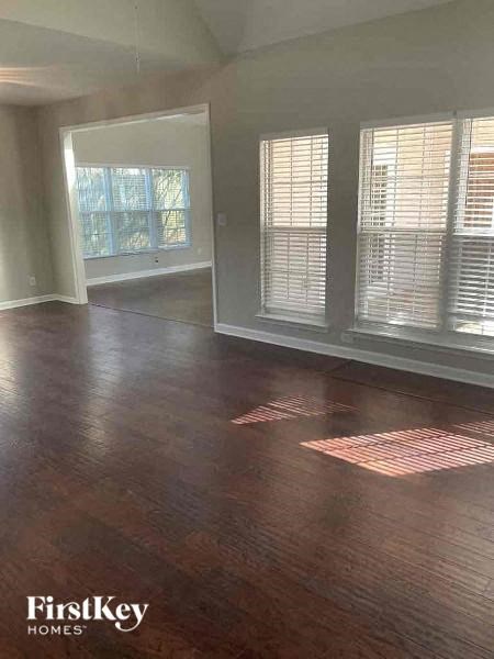an empty living room with wood floors and windows