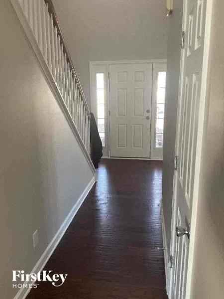 a hallway with a wooden floor and a white door