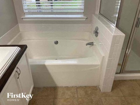 a white bath tub in a bathroom with a window