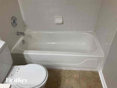 a bathroom with a white toilet and a bath tub