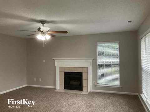 a living room with a fireplace and a ceiling fan