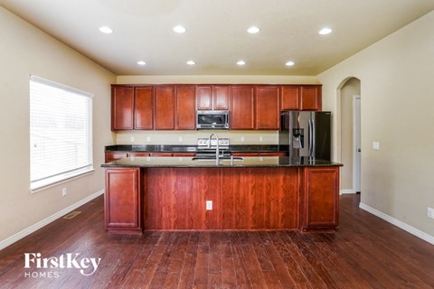an empty kitchen with wooden cabinets and a counter top