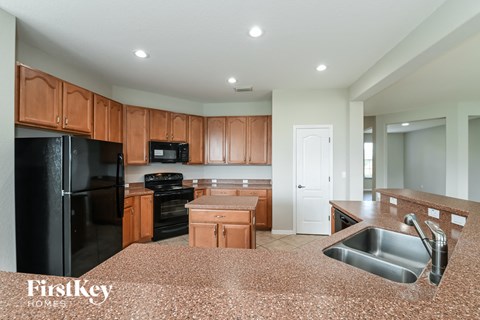 a kitchen with wooden cabinets and black appliances and granite counter tops