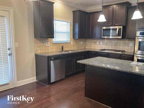 a kitchen with black cabinets and stainless steel appliances