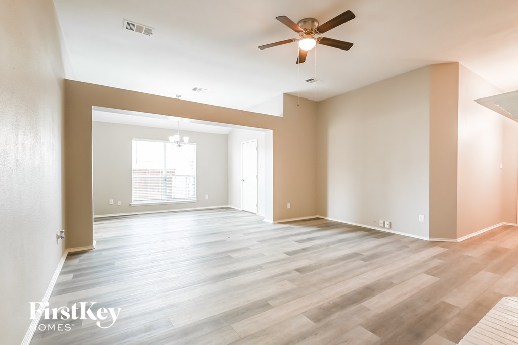 a living room with wood floors and a ceiling fan
