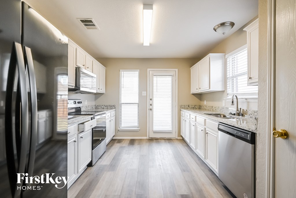 a kitchen with white cabinets and stainless steel appliances