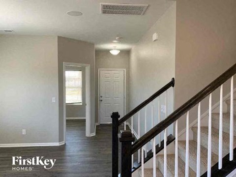 a hallway with stairs and a white door