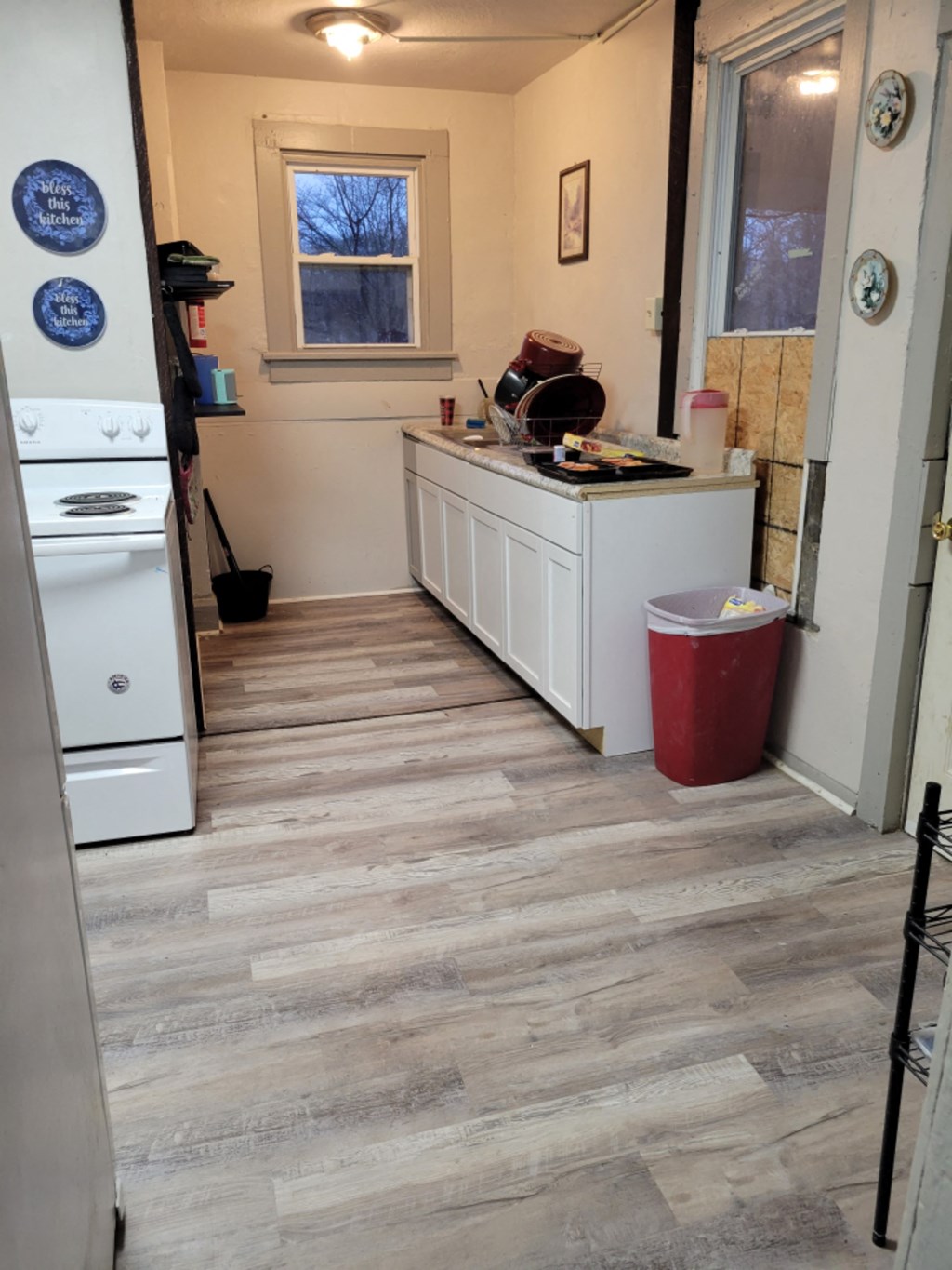 a kitchen with a wooden floor and white cabinets