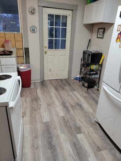 a kitchen with wooden floors and a white door
