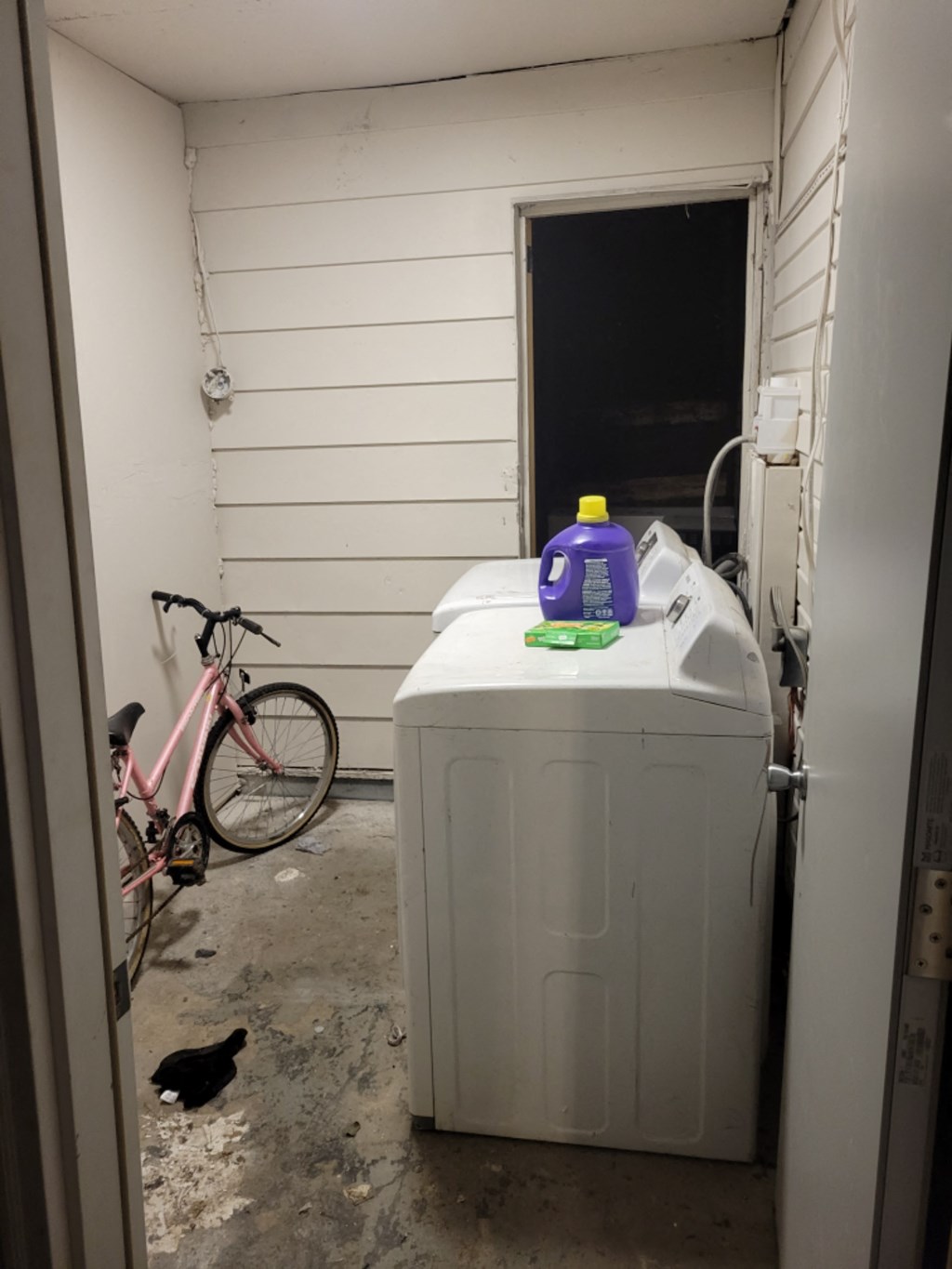 the laundry room has a washer and dryer in it and a pink bike