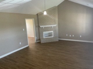 A living room with a fireplace and wood flooring.